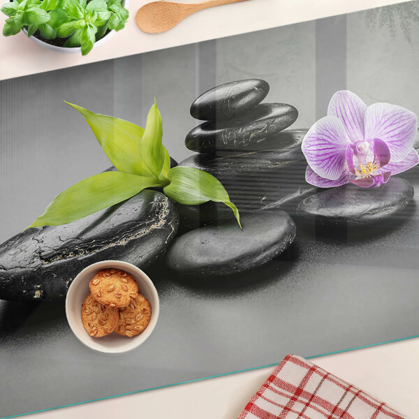 Tabla de cocina Piedras y orquídea al fondo.