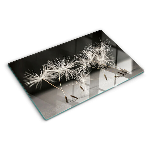 Tabla de cortar Dientes de león esponjosos sobre un fondo monocromático