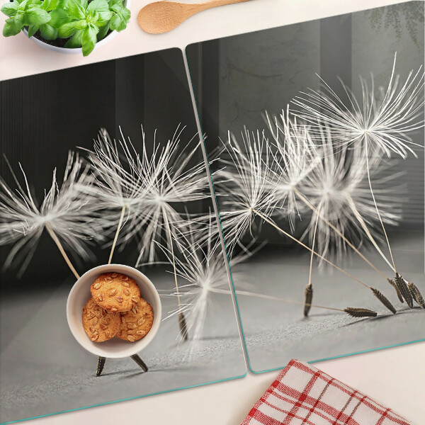 Tabla de cortar Dientes de león esponjosos sobre un fondo monocromático