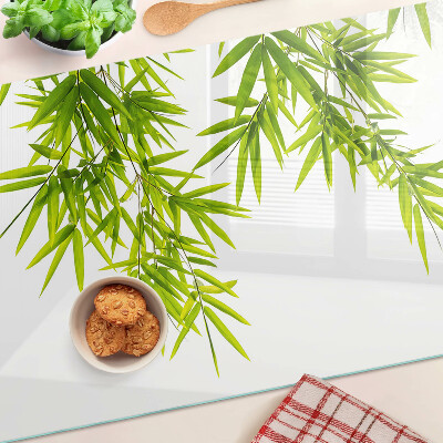 Tabla de cortar Hojas de bambú contra el fondo de la ventana.