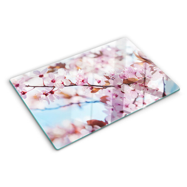 Tabla de cortar de cristal Flores de cerezo sobre un fondo azul