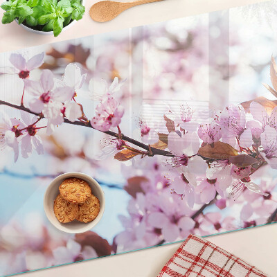 Tabla de cortar de cristal Flores de cerezo sobre un fondo azul
