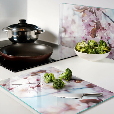 Tabla de cortar de cristal Flores de cerezo sobre un fondo azul