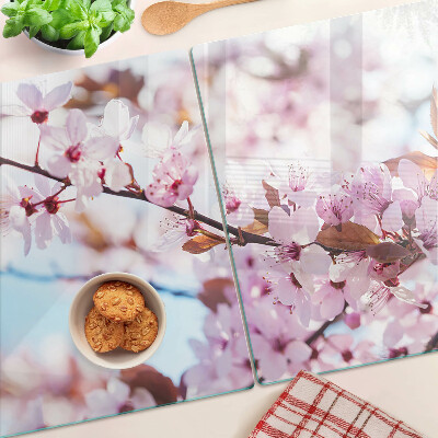 Tabla de cortar de cristal Flores de cerezo sobre un fondo azul
