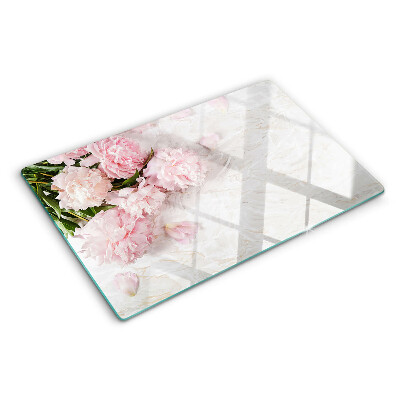 Tabla para cortar Flores de peonía sobre un fondo de mármol.