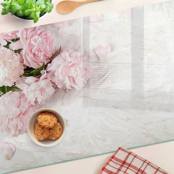 Tabla para cortar Flores de peonía sobre un fondo de mármol.
