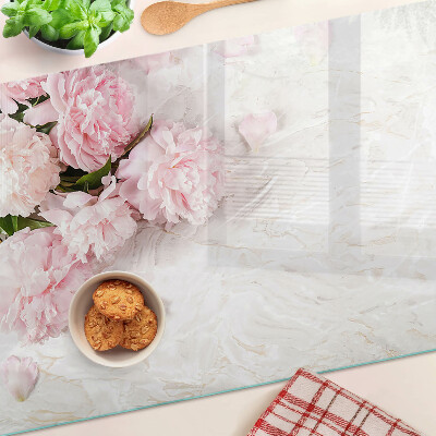 Tabla para cortar Flores de peonía sobre un fondo de mármol.