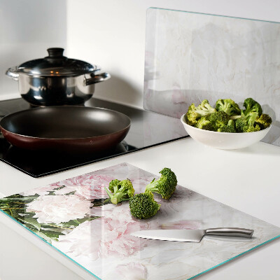 Tabla para cortar Flores de peonía sobre un fondo de mármol.