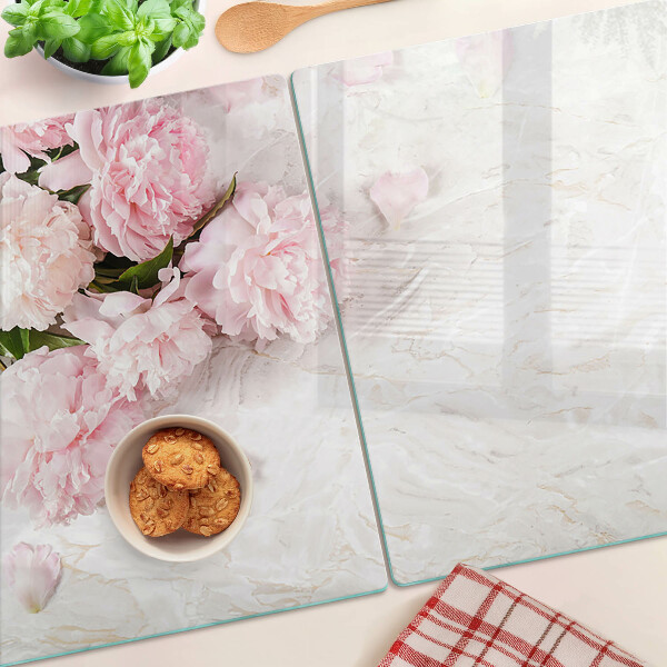Tabla para cortar Flores de peonía sobre un fondo de mármol.