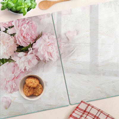 Tabla para cortar Flores de peonía sobre un fondo de mármol.