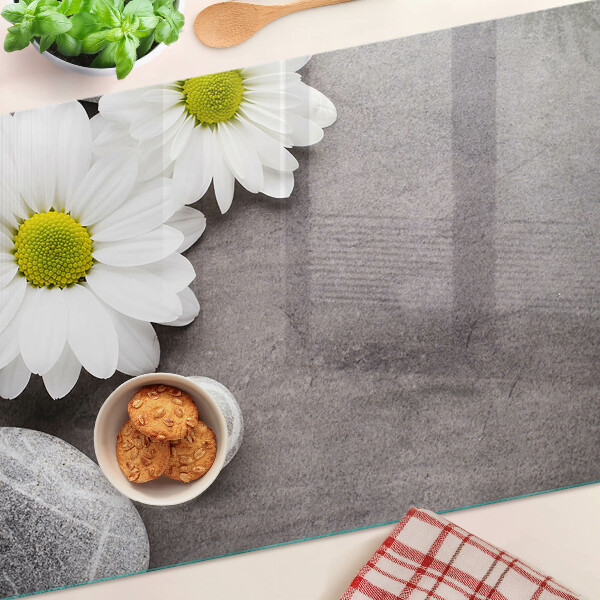 Tabla de cortar Flores y piedras al fondo.