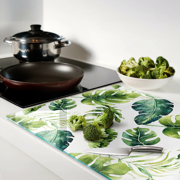 Tabla de cortar de cristal Hojas de monstera en tonos verdes.