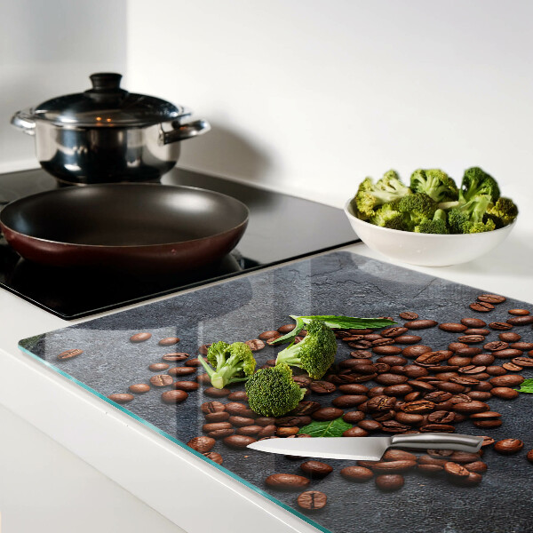 Tabla de cortar de cristal Granos de café sobre un fondo de piedra