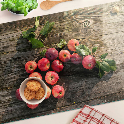 Tabla de cortar de cristal Manzanas sobre un fondo de madera