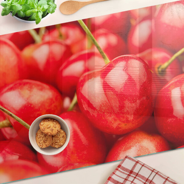 Tabla de cortar de cristal Cerezas sobre fondo rojo
