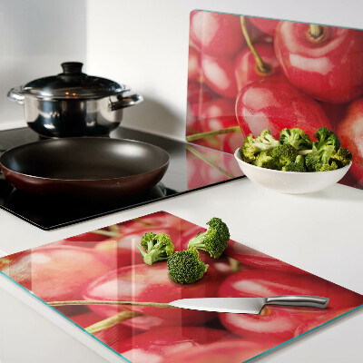 Tabla de cortar de cristal Cerezas sobre fondo rojo