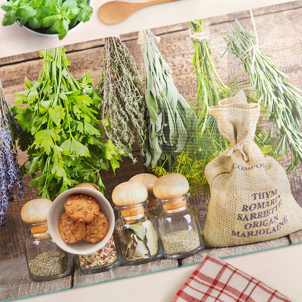 Tabla de cortar de cristal Hierbas y especias sobre un fondo de madera.