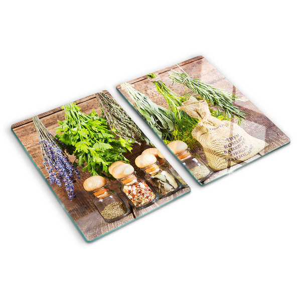 Tabla de cortar de cristal Hierbas y especias sobre un fondo de madera.