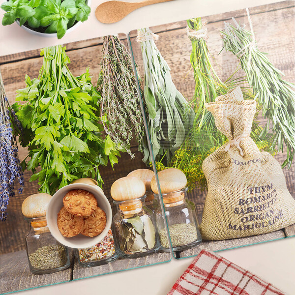 Tabla de cortar de cristal Hierbas y especias sobre un fondo de madera.