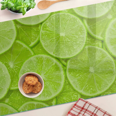 Tabla de cortar Rodajas de lima sobre un fondo verde