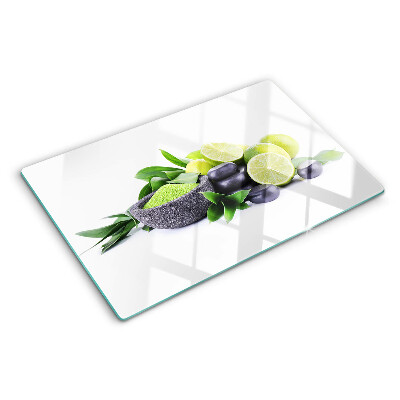 Tabla de cortar de cristal Limones y uvas sobre un fondo verde.