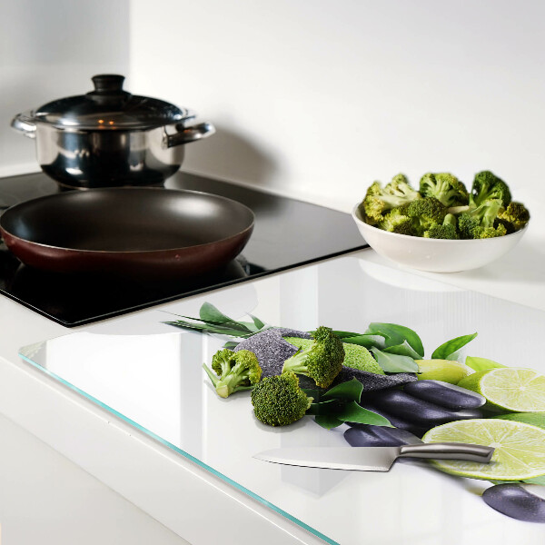 Tabla de cortar de cristal Limones y uvas sobre un fondo verde.