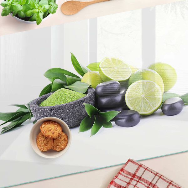 Tabla de cortar de cristal Limones y uvas sobre un fondo verde.