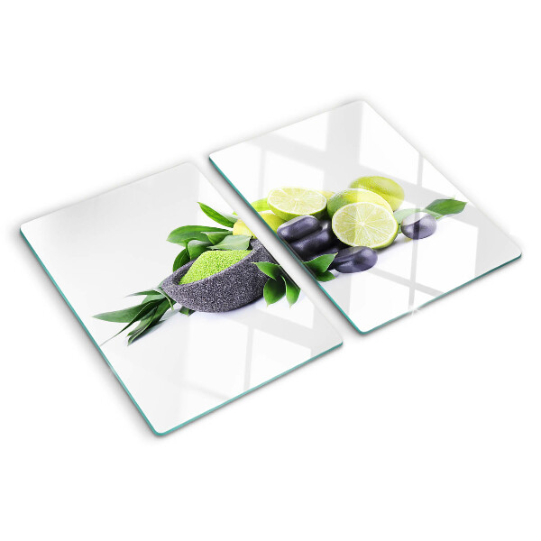 Tabla de cortar de cristal Limones y uvas sobre un fondo verde.