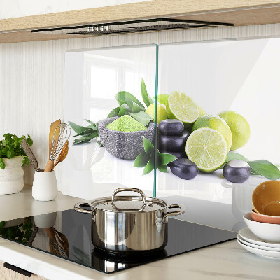 Tabla de cortar de cristal Limones y uvas sobre un fondo verde.