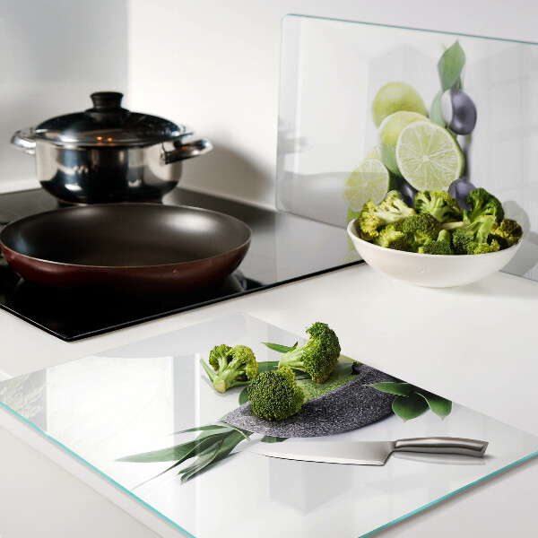 Tabla de cortar de cristal Limones y uvas sobre un fondo verde.