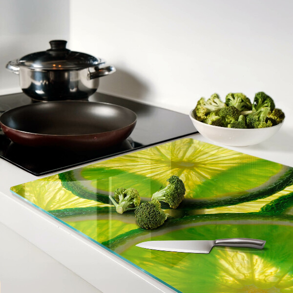 Tabla de cocina Rodajas de lima sobre un fondo verde