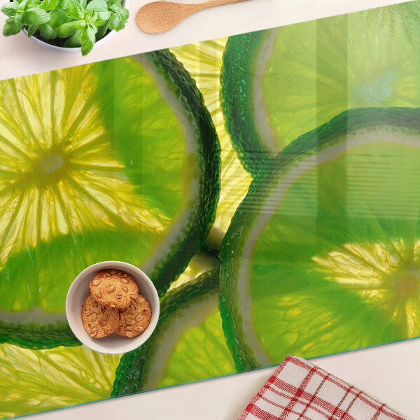 Tabla de cocina Rodajas de lima sobre un fondo verde