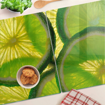 Tabla de cocina Rodajas de lima sobre un fondo verde