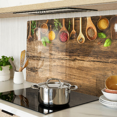 Tabla de cortar de cristal Especias y hierbas sobre un fondo de madera.