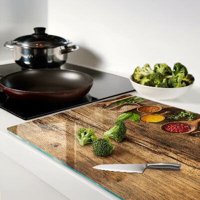 Tabla de cortar de cristal Especias y hierbas sobre un fondo de madera.