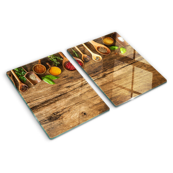 Tabla de cortar de cristal Especias y hierbas sobre un fondo de madera.