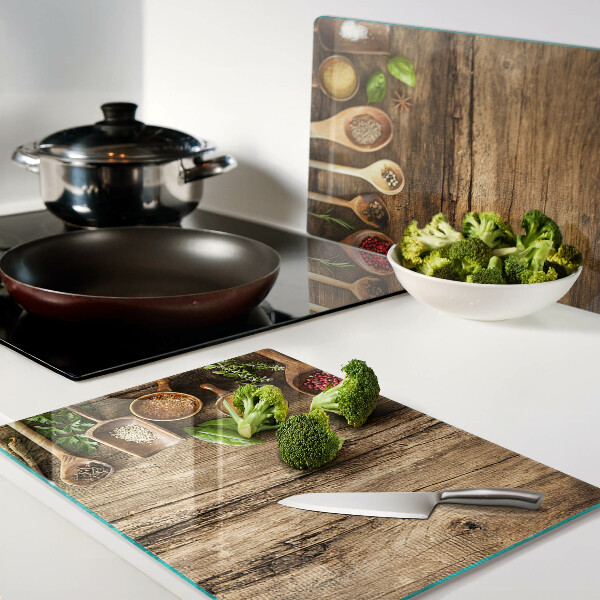 Tabla de cortar de cristal Especias y hierbas sobre un fondo de madera.