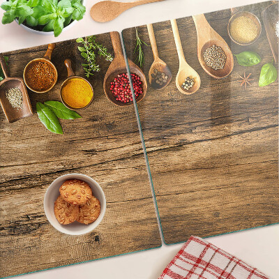 Tabla de cortar de cristal Especias y hierbas sobre un fondo de madera.