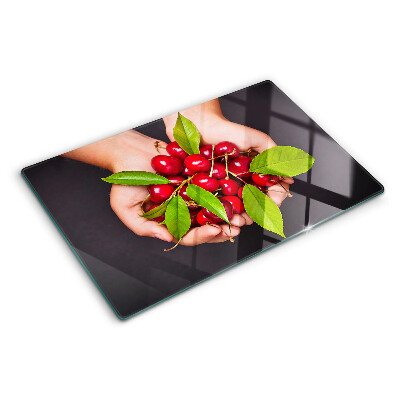 Tabla para cortar Cerezas rojas en las manos