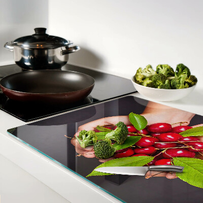 Tabla para cortar Cerezas rojas en las manos