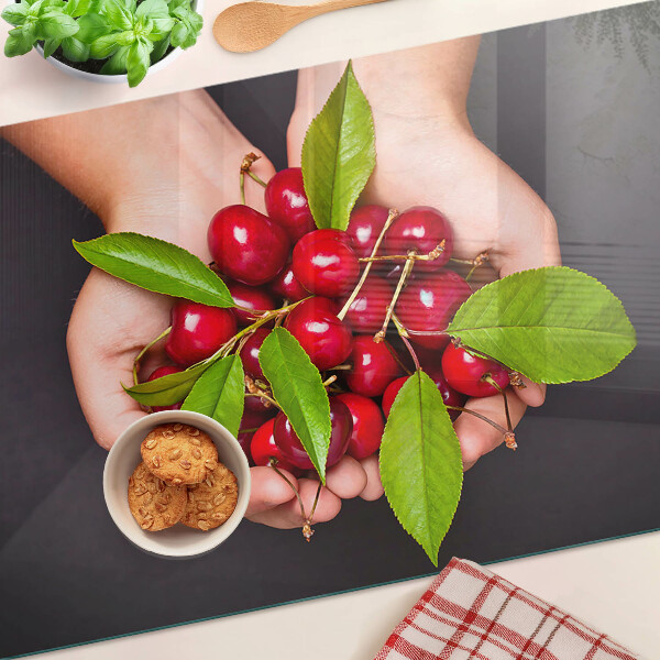 Tabla para cortar Cerezas rojas en las manos