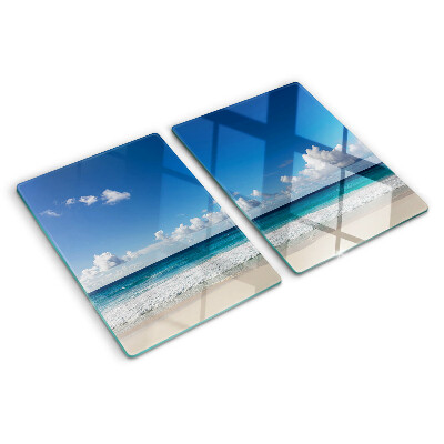 Tabla de cortar de cristal Una playa con agua turquesa y nubes.