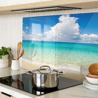 Tabla de cortar de cristal Una playa con agua turquesa y nubes.