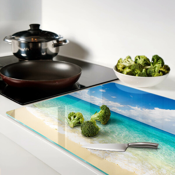 Tabla de cortar de cristal Una playa con agua turquesa y nubes.