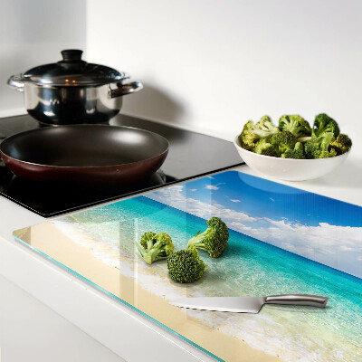 Tabla de cortar de cristal Una playa con agua turquesa y nubes.