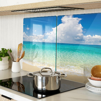 Tabla de cortar de cristal Una playa con agua turquesa y nubes.