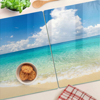 Tabla de cortar de cristal Una playa con agua turquesa y nubes.