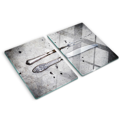Tabla de cortar de cristal Cubiertos sobre un fondo de hormigón