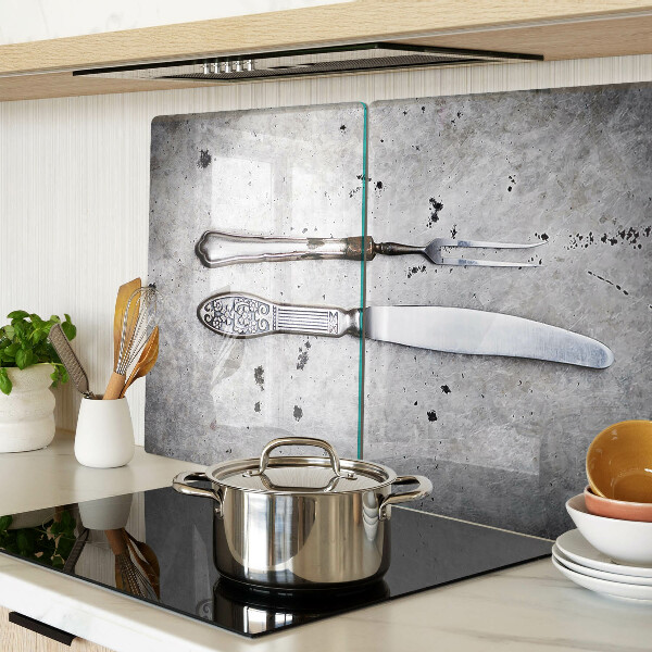 Tabla de cortar de cristal Cubiertos sobre un fondo de hormigón