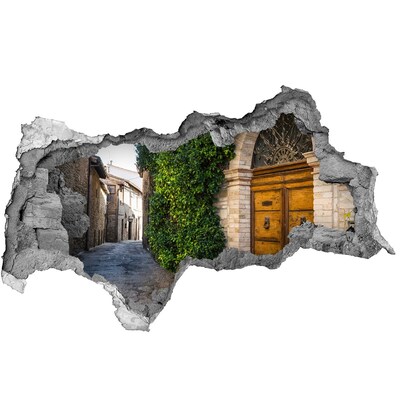 Vinilo adhesivo boquete en la pared rota Un encantador callejón en la ciudad.